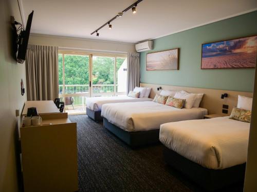 黄金海岸Nightcap at Hinterland Hotel Nerang的酒店客房设有两张床和窗户。
