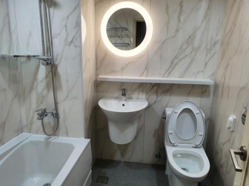 釜山普瑞玛观光酒店的一间带卫生间、水槽和镜子的浴室