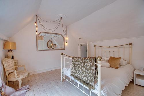 贝里圣埃德蒙兹Sweet & cosy 10 Bridewell Cottage with parking available upon request的卧室配有白色的床和椅子