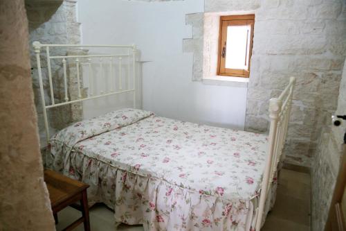 阿尔贝罗贝洛Trullo Montetrecarlini的一间白色卧室,卧室内配有一张床