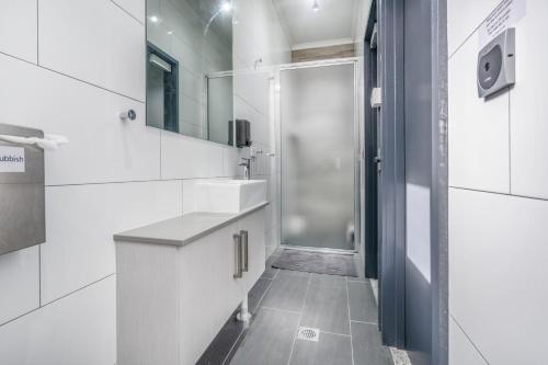 因尼斯费尔Alberts Est 2017的白色的浴室设有水槽和淋浴。