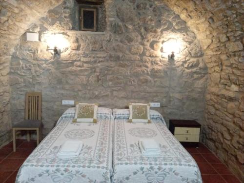 伊萨韦纳河畔罗达Casa "La Huerta" DE RODA DE ISABENA的卧室配有一张石墙床