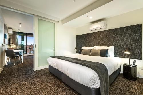 墨尔本Corporate Living Accommodation Abbotsford的一间卧室设有一张大床和一个滑动玻璃门