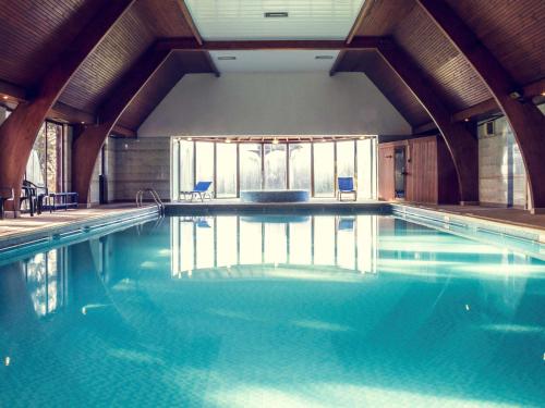 赫尔赫尔格兰奇公园美居酒店的大楼内的一个蓝色海水游泳池