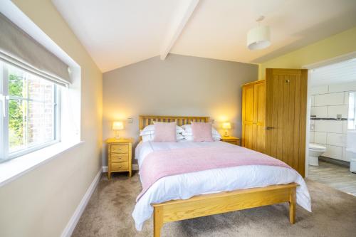 约克Brecks Farm - Well Cottage的一间卧室设有一张大床和一个窗户。