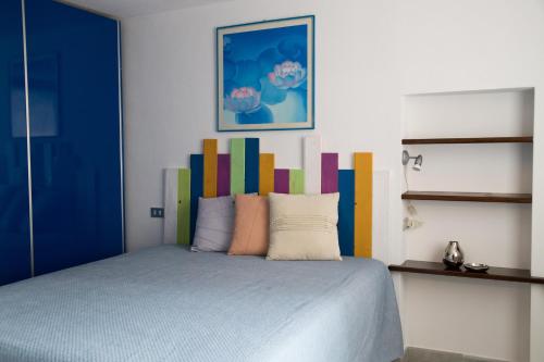 奥斯塔Maison Poppy的一间卧室配有一张带色彩缤纷床头板的床