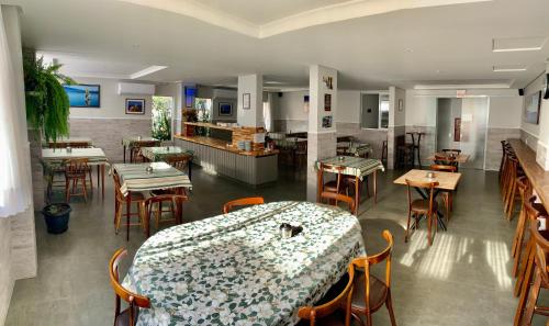 帕罗卡Hotel Pontal的一间带桌椅和柜台的餐厅