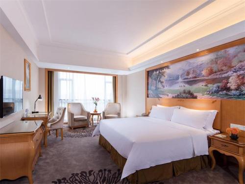 宝安维也纳酒店深圳沙井上南店的酒店客房设有一张大床和一张书桌。