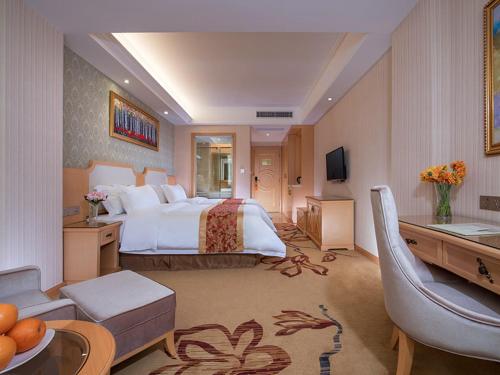 Fenghuangwei维也纳酒店深圳福永村店的大型酒店客房设有床和客厅。