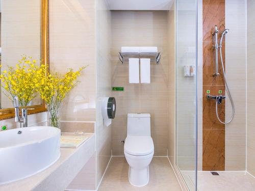 宝安维也纳酒店深圳石岩石龙社区店的浴室配有卫生间、盥洗盆和淋浴。