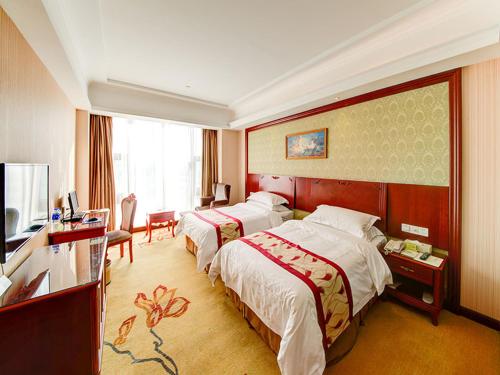 上海维也纳酒店上海嘉定新城店的酒店客房设有两张床和电视。