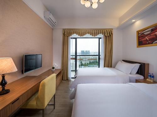 惠州维也纳国际公寓惠州大亚湾世纪城店的酒店客房设有两张床和电视。