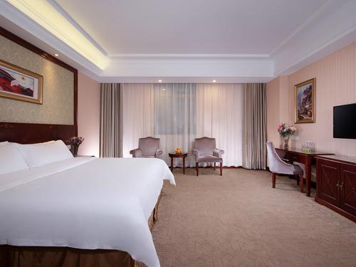 广州维也纳酒店广州番禺南村店的酒店客房设有一张大床和一张书桌。