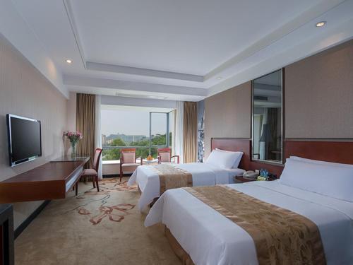 东莞维也纳酒店东莞厚街大道店的酒店客房设有两张床和电视。
