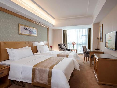 广州维也纳酒店广州番禺大石桥店的酒店客房配有两张床和一张书桌