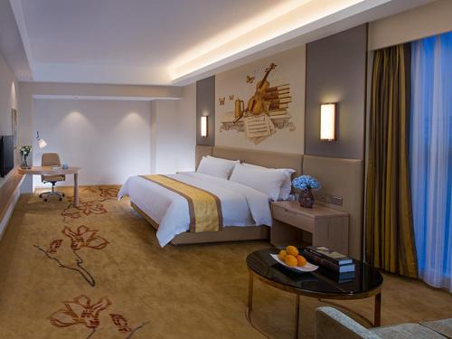 杭州维也纳国际酒店杭州东站店的酒店客房设有一张大床和一张桌子。