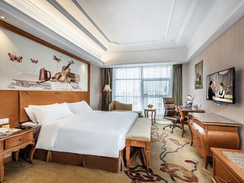 信阳维也纳国际酒店河南信阳羊山新区店的酒店客房设有一张大床和一张书桌。