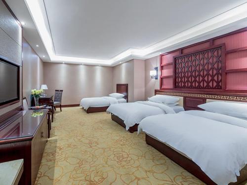 昆明维也纳智好酒店昆明彩云北路新亚洲店的酒店客房设有四张床和平面电视。