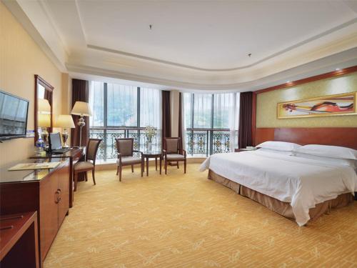 广州维也纳酒店广州同和店的大型酒店客房,配有一张床和一张书桌