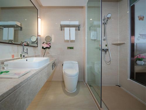 景洪市维也纳国际酒店 (云南西双版纳景洪告庄滨江俊园店)的浴室配有卫生间、盥洗盆和淋浴。