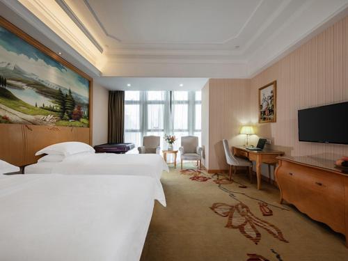 福州维也纳国际酒店福州仓山万达店的酒店客房设有两张床和一台平面电视。