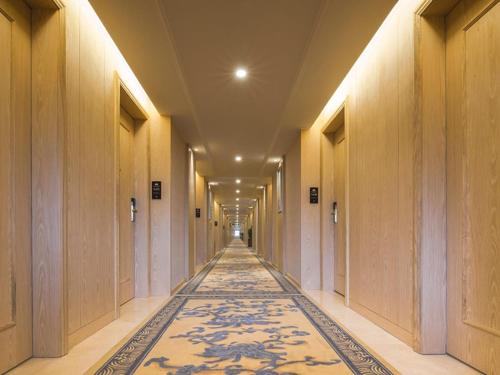 深圳维也纳酒店深圳华强北店的地板上铺着地毯的空走廊