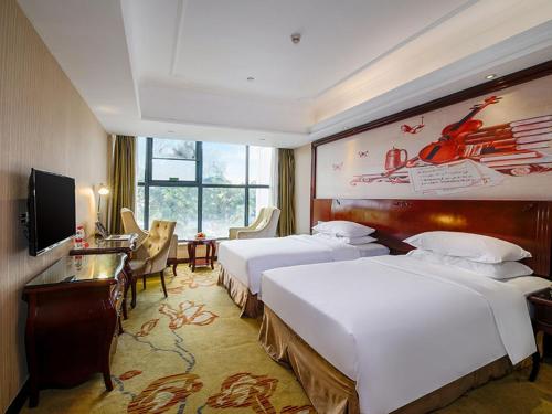 深圳维也纳酒店深圳水库新村店的酒店客房配有两张床和一张书桌