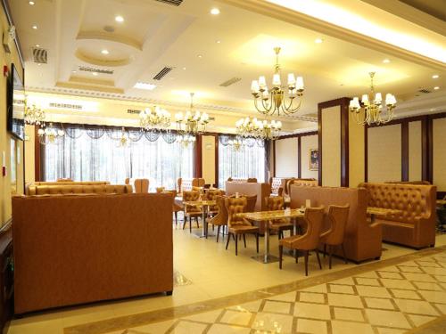 长沙维也纳国际酒店湖南长沙岳麓银杉路店的餐厅设有桌椅和吊灯。