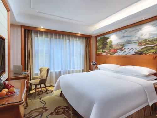 南京维也纳国际酒店江苏南京南站中心店的酒店客房设有一张白色大床和一个窗户。