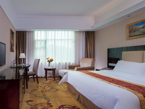 西乡维也纳酒店深圳宝安流塘店的酒店客房设有一张大床和一张书桌。