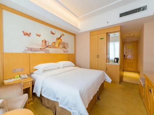 西宁维也纳酒店青海西宁胜利路店的卧室配有一张白色大床和一张书桌