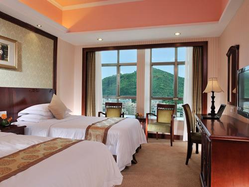 深圳维也纳酒店大学城店的酒店客房设有两张床、一张书桌和一个窗户。