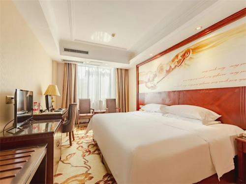 桂林维也纳酒店桂林火车站店的酒店客房设有一张大床和一张书桌。