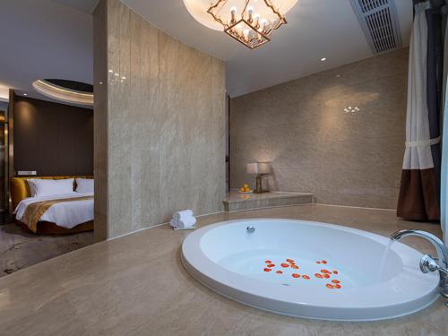 桂林维也纳国际酒店(桂林万达高铁站店)的带浴缸的浴室,后面配有一张床