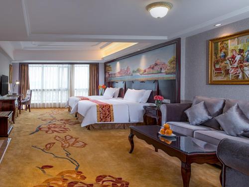 惠东维也纳国际纳酒店惠州惠东红海湾店的酒店客房,配有床和沙发