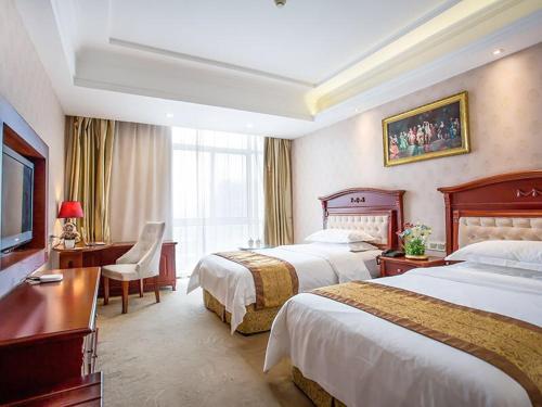 苏州维也纳酒店苏州乐园店的酒店客房配有两张床和一张书桌