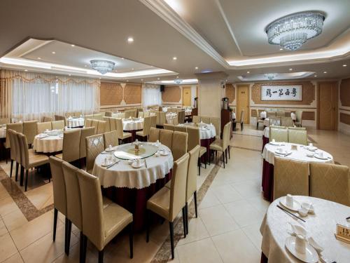 广州维也纳国际酒店广州机场新市店的一间在房间内配有桌椅的餐厅