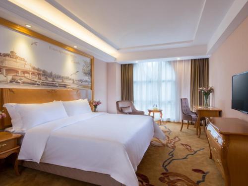 深圳维也纳酒店深圳罗芳店的酒店客房设有一张白色大床和一台电视。