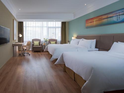 澄迈维也纳3好酒店 (海口澄迈老城店)的酒店客房设有两张床和电视。