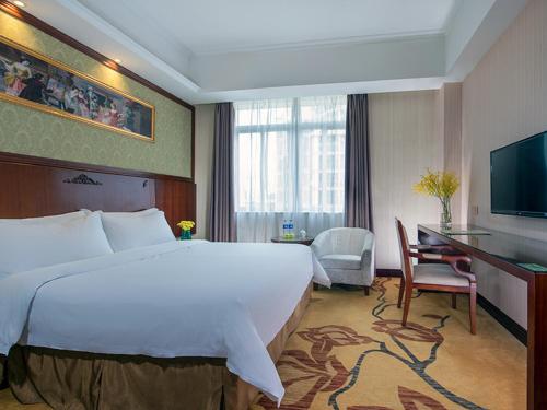 广州维也纳酒店番禺市桥地铁站店的酒店客房设有一张大床和一张书桌。