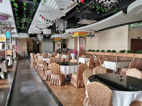 龙岗维也纳酒店深圳龙岗南联店的用餐室配有桌椅和吊灯。