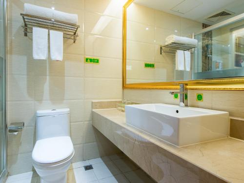 龙岗维也纳酒店坂雪岗大道店的一间带水槽、卫生间和镜子的浴室