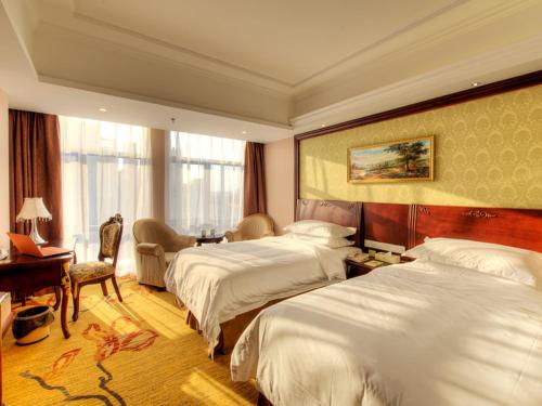 松江维也纳酒店(上海欢乐谷店)的酒店客房配有两张床和一张书桌