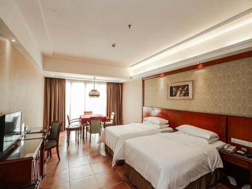 东莞维也纳酒店东莞厚街万达广场店的酒店客房配有两张床和一张书桌