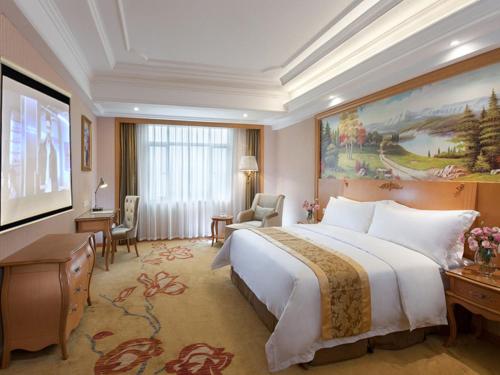 广州维也纳酒店广州南浦地铁站店的酒店客房设有一张大床和一张大型绘画
