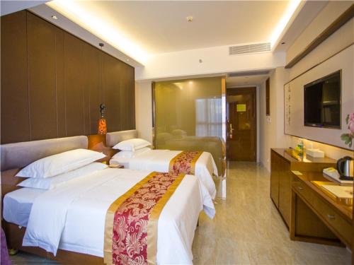 三亚维也纳酒店海南三亚三亚湾店的酒店客房设有两张床和电视。