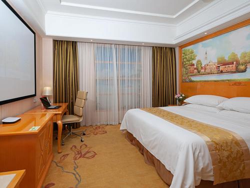 青浦维也纳酒店上海虹桥国展中心华新店的酒店客房设有一张大床和一张书桌。
