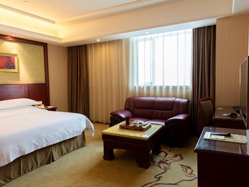 佛山维也纳酒店佛山季华路店的配有一张床和一把椅子的酒店客房
