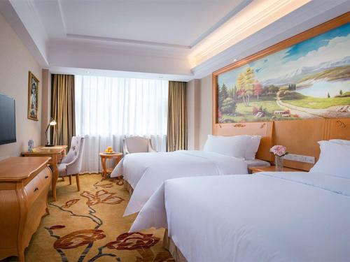 深圳维也纳酒店深圳罗湖口岸店的酒店客房配有两张床和一张书桌