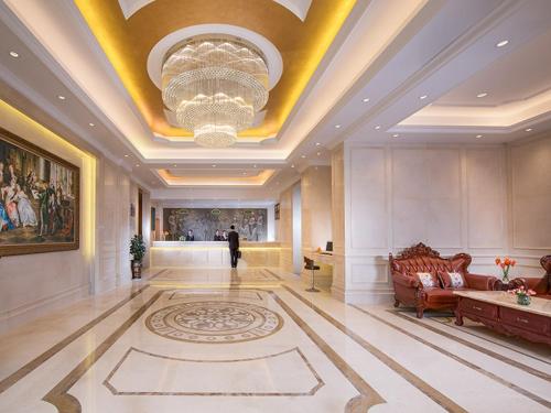 宝安维也纳酒店深圳福永地铁站店的一个带沙发和吊灯的大型大堂